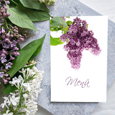 Tisch mit Flieder und passender Menükarte